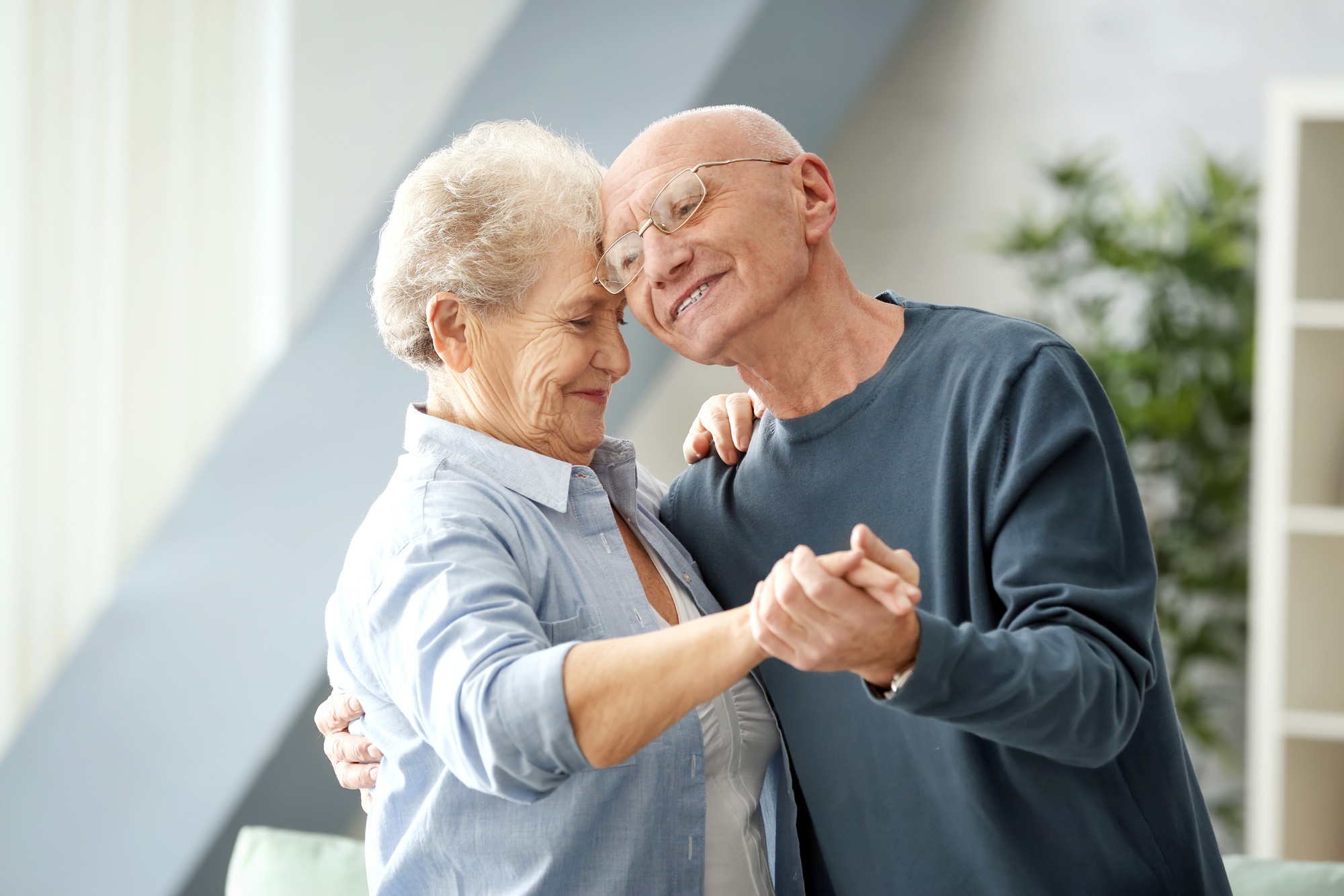 Happy, smiling, seniors couple dancing in living room