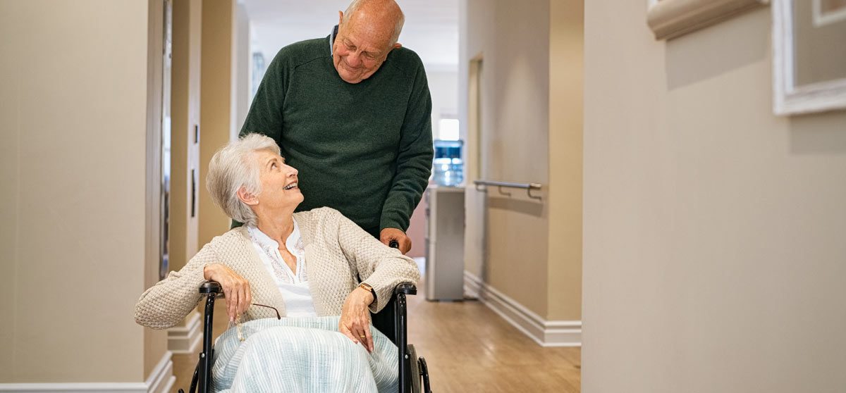 VRS Garneau Hall senior man visiting disabled woman on wheelchair at nursing home