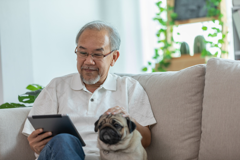 Senior on iPad tablet with dog at VRS retirement home in Edmonton